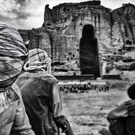 Afghan men gather in front of the remains of the statue of the big Buddha.